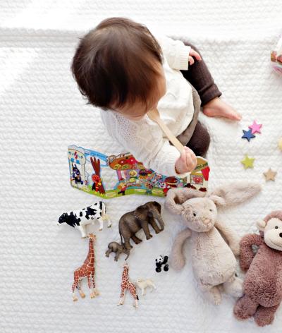 A baby surrounded by many toys.