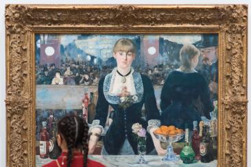 A woman viewing Manet's A Bar at the Folies-Bergère
