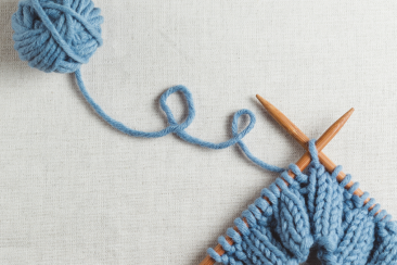Blue knitting on wooden knitting needles