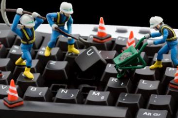 Toy workmen on a computer keyboard
