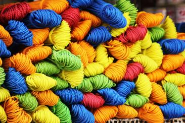 Colour photo of skeins of yarn in blue, red, yellow, green and orange