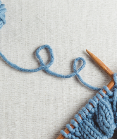 Blue knitting on wooden knitting needles