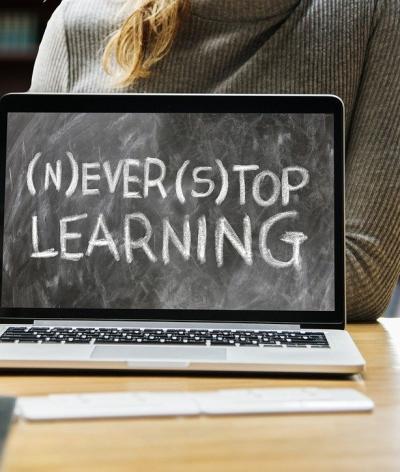 A laptop screen reading 'never stop learning'