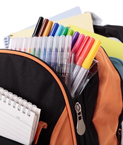 Colour photo of backpack full of notebooks, felt tips pens, pencils etc
