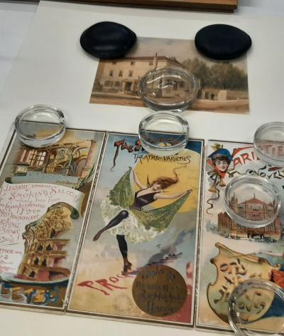 a selection of colourful victorian posters being prepared for display in an exhibition