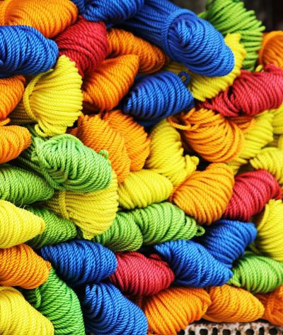 Colour photo of skeins of yarn in blue, red, yellow, green and orange