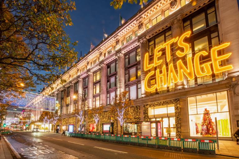 Shopping in the West End - message on building says 'let's change'.