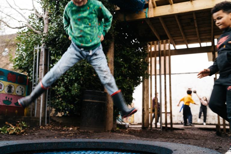 Image of two children jumping on a trampoline 