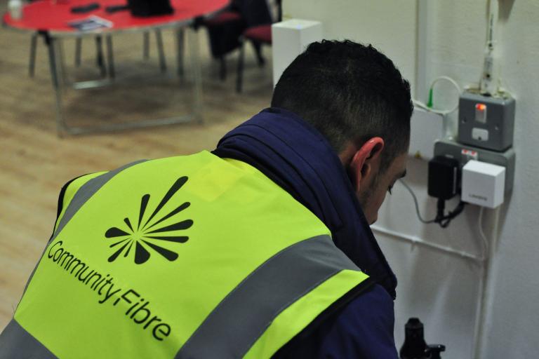 Man wearing a hi-vis jacket saying 'Community Fibre' installing high speed broadband 