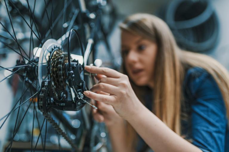 A woman repairing bike gears