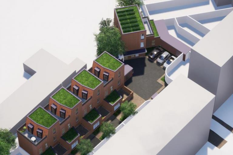 A CGI image of the proposals to build new family homes in red coloured bricks, in two blocks, one consisting of four main sections and another of a single block. Cars feature in the CGI and other surrounding buildings are represented by grey and white blocks.