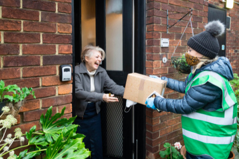 Westminster City Council volunteer delivering a christmas hamper to an old woman