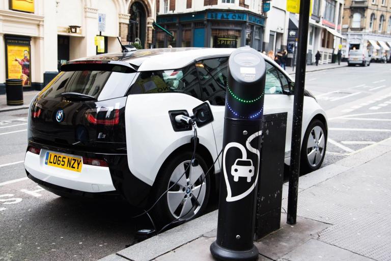A car at an electric car charging point parked on the side of the road