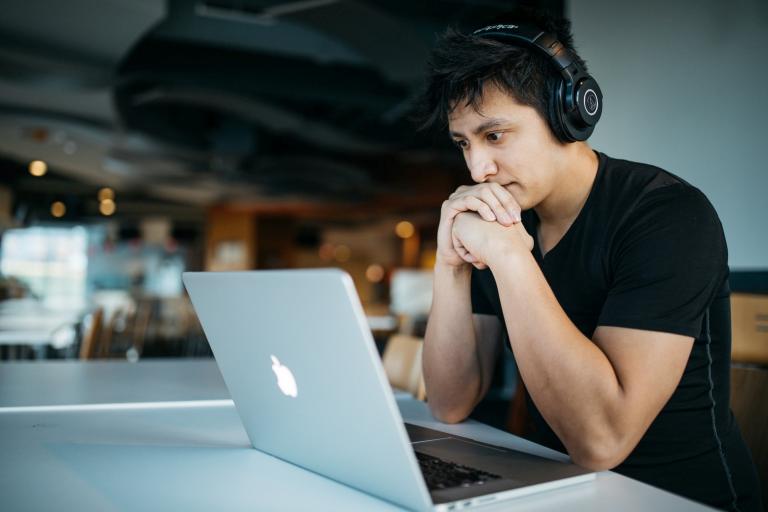 Man on laptop in headphones