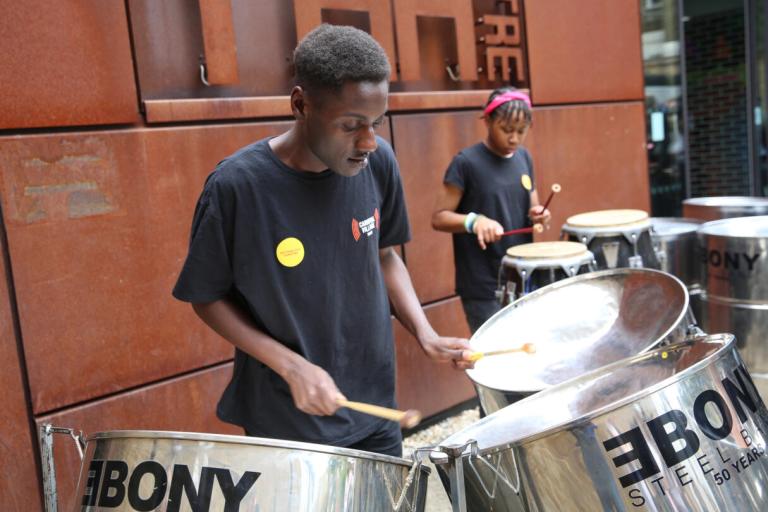 two young people playing steel pan