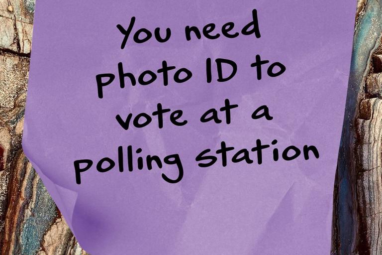 A post it note that says 'you need photo ID to vote at a polling station'