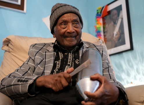 90-year-old Cyril Khamai from Maida Hill playing his musical instrument - a metal scratcher