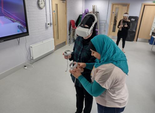 Two women experimenting with a virtual reality headset in a council-run project to calm the effects of serious youth violence
