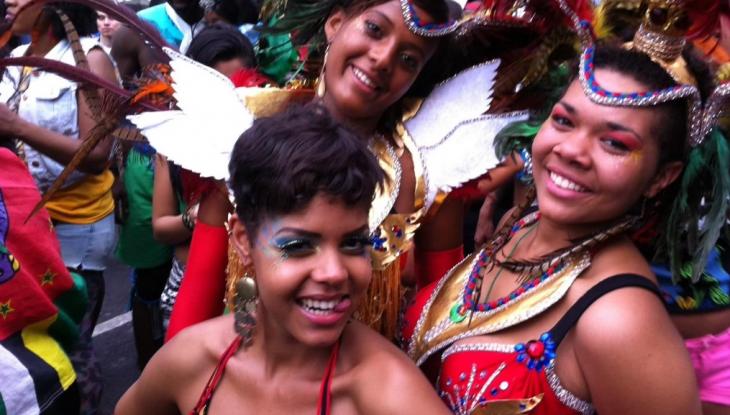 image of 3 women dressed up in typical notting hill carnival festival clothes, smiling.