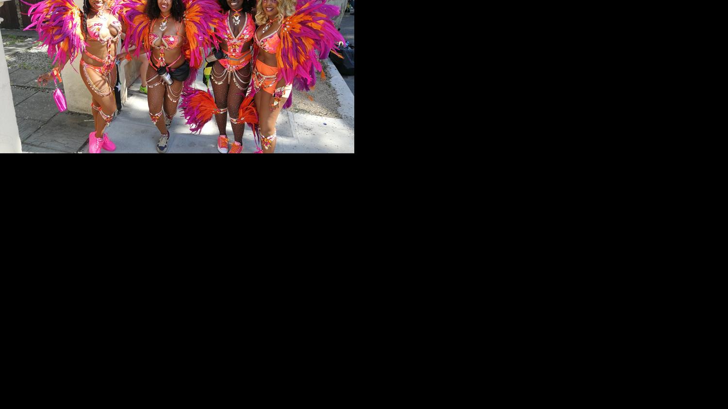 image of 4 women dressed up in typical notting hill carnival festival clothes, smiling.