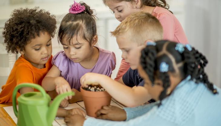 Kids planting seeds in a plant pot