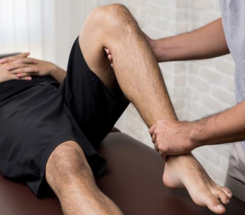 An osteopath treating a man's knee
