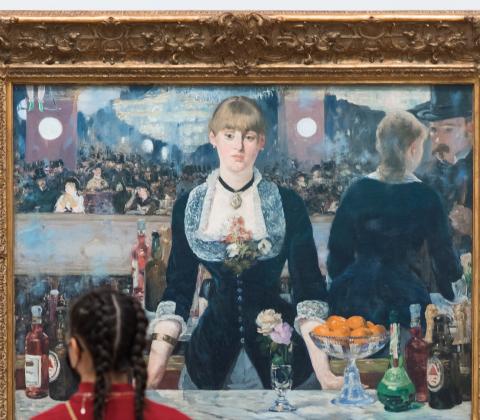 A woman viewing Manet's A Bar at the Folies-Bergère