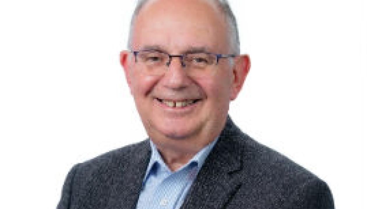A headshot of Cllr Paul Dimoldenberg smiling to the camera